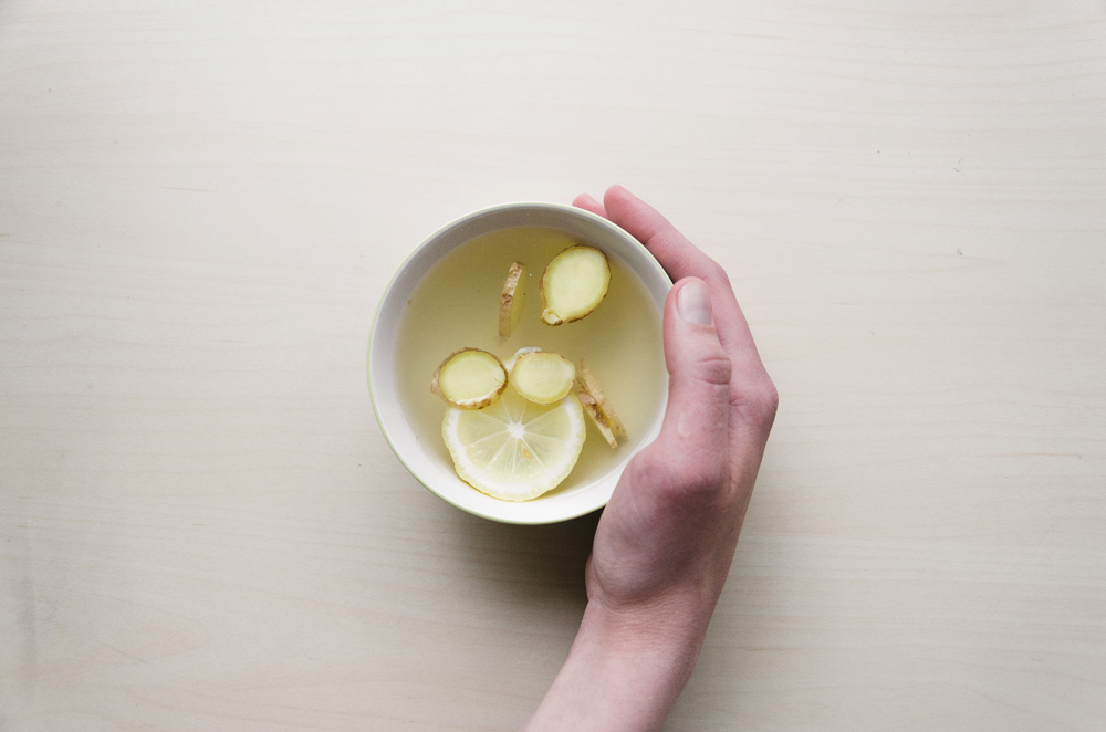 Slices of ginger and lemon in a mug filled with hot water