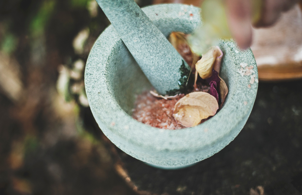 A mortar and pestle filled with rose petals