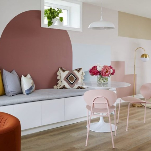 Breakfast nook in with a feature wall with pink colour blocked shapes painted on as seen on Save My Reno on HGTV Canada