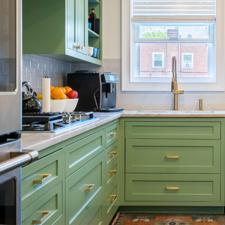 Kitchen with green cabinets and gold hardware