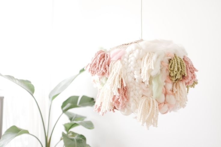 A closer look at the DIY lampshade, hanging in front of a tall indoor plant.
