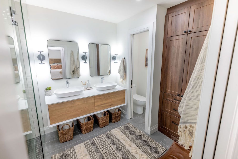 A brand-new master bathroom with a modern dual-sink floating vanity, blended-tone tile floor and sleek fixtures to further enhance the retreat-worthy feel of the space as featured on HGTV Canada