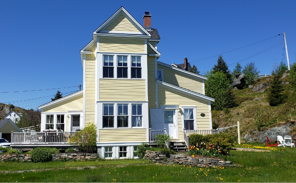 Yellow shiplap house in Brigus Bay Newfoundland
