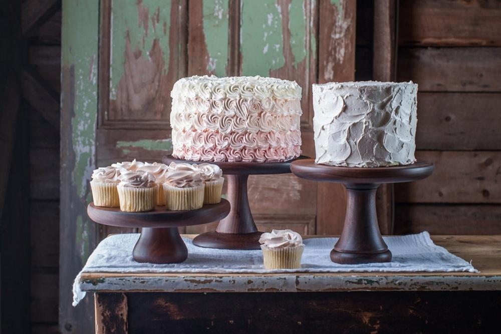 Three walnut cake stands with two cakes and cupcakes