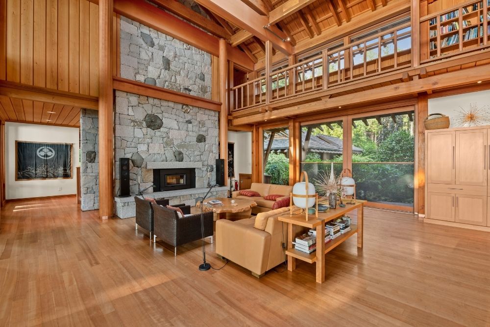 This West Coast cottage features a spacious luxury living room with high ceilings and wood detailing throughout.