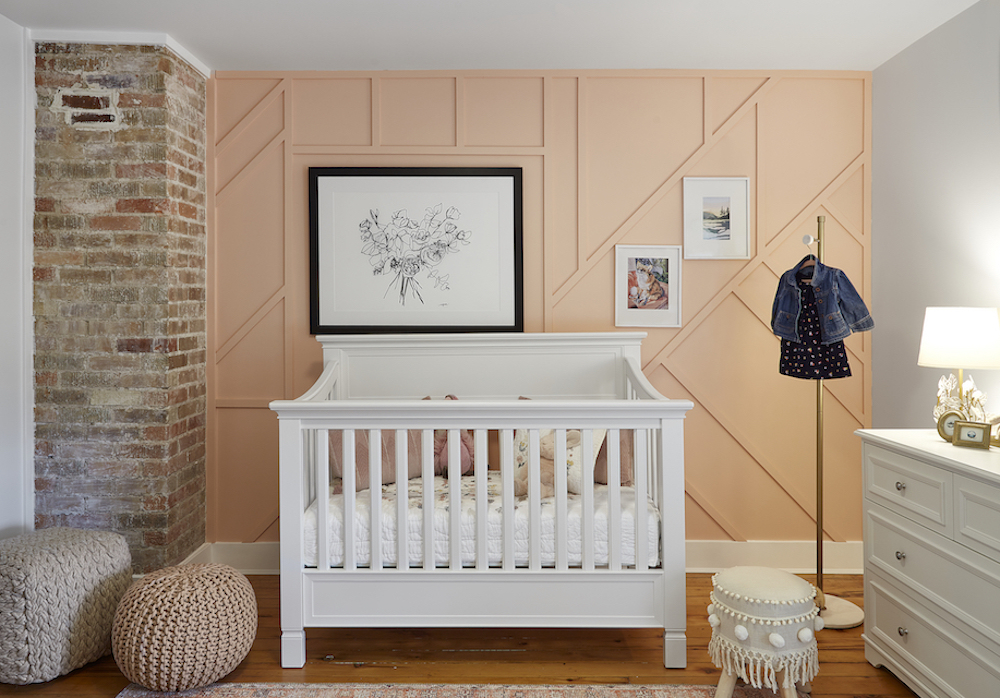 Fun nursery with a crib that converts into a bed, original hardwood floors, exposed original chimney stack, coral feature wall with added wainscoting, and custom art on the walls as featured on HGVT Canada
