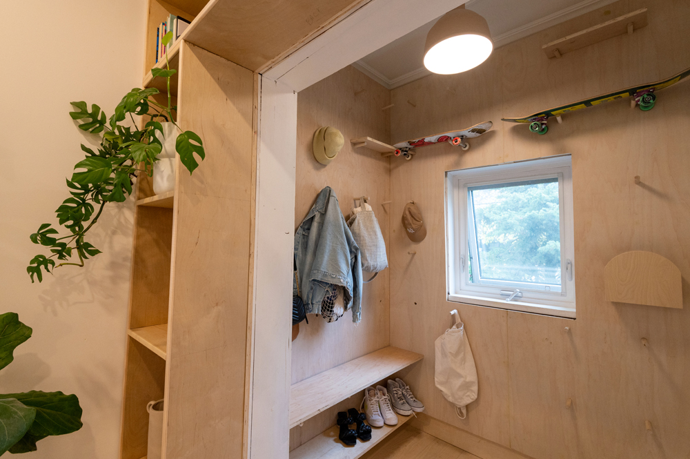 Amy Highton house tour in Calgary - plywood boards and pegs for maximizing foyer storage space