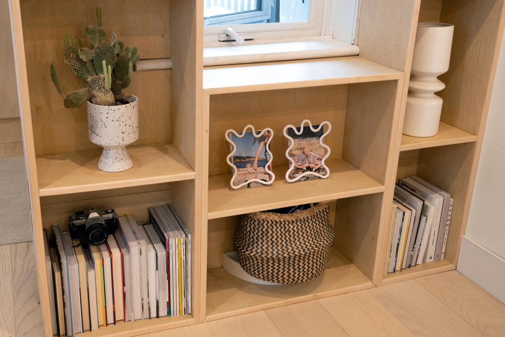 Amy Highton's Calgary house - eclectic, whimsical photo frames in an otherwise minimalistic shelf-scape