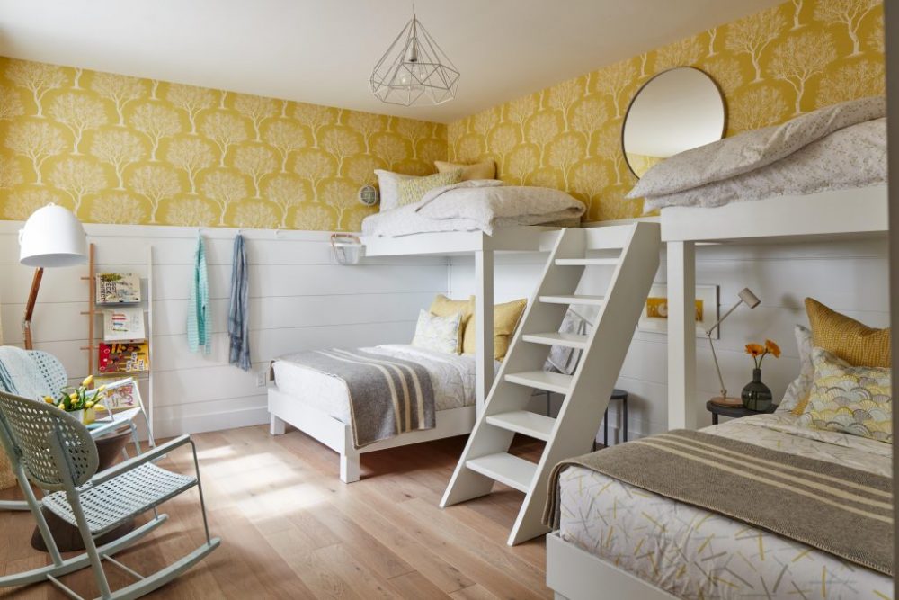 Yellow and white kids' room in basement with four beds