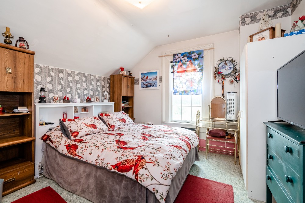 outdated farmhouse bedroom with grey and white wallpaper and red and white cardinal bedding
