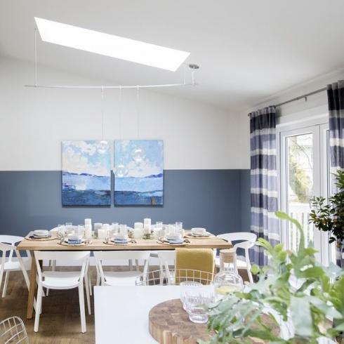 A blue and white kitchen with a skylight