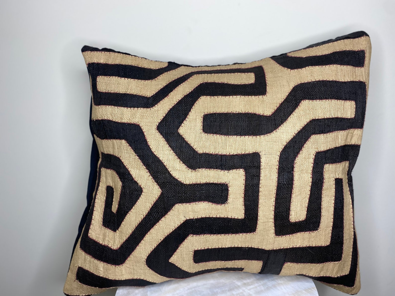Gorgeous kuba raffia cushion cover with geometric patterns in earth tones.