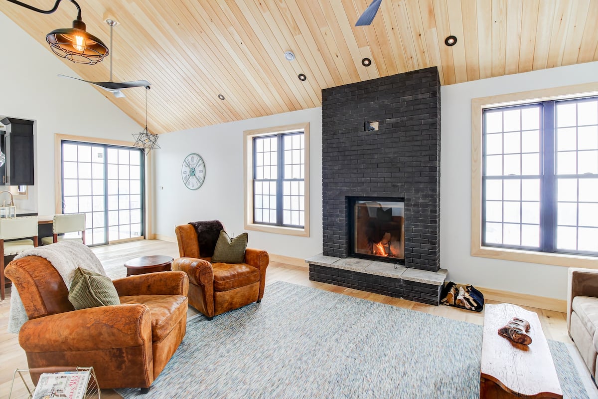 living room in vacation property with high ceilings and brick fireplace
