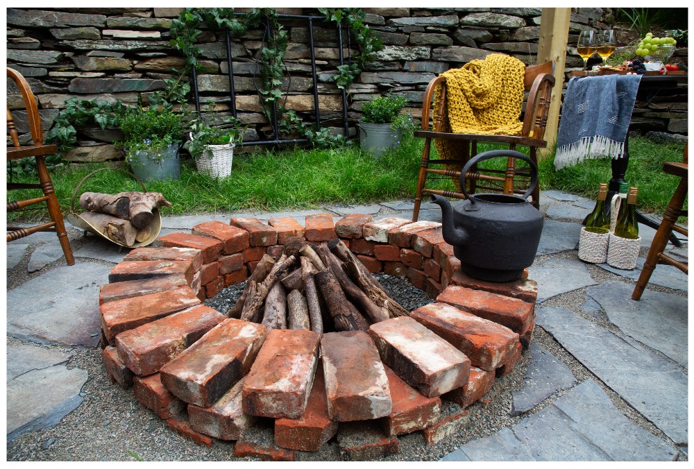 Red brick firepit with wood and a kettle