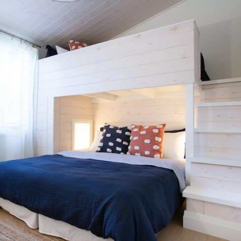 Wooden bunk bed painted white with navy blue bedding