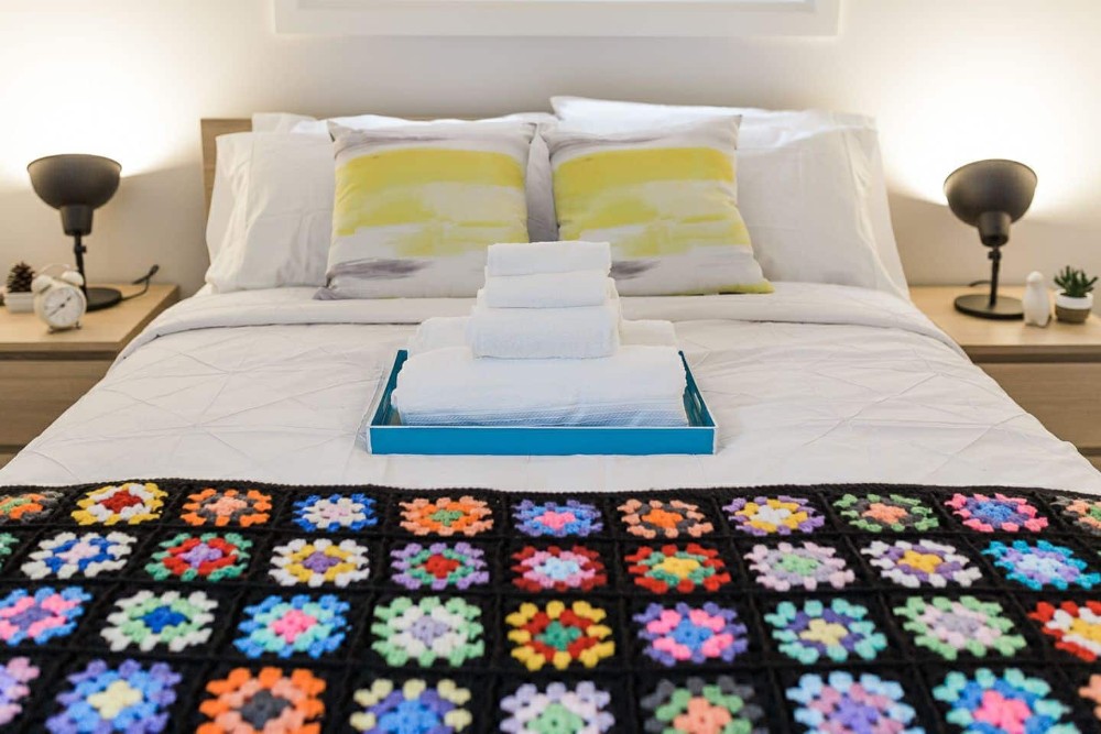 Guest bedroom with colourful bed throw