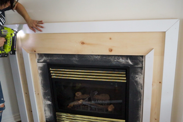 Adding trim to the fireplace for a clean, professional finish.