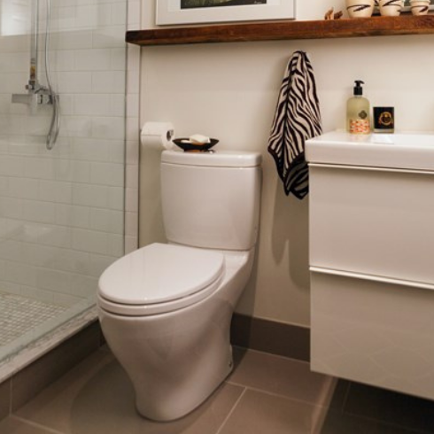 A clean white toilet in a brown and white bathroom.