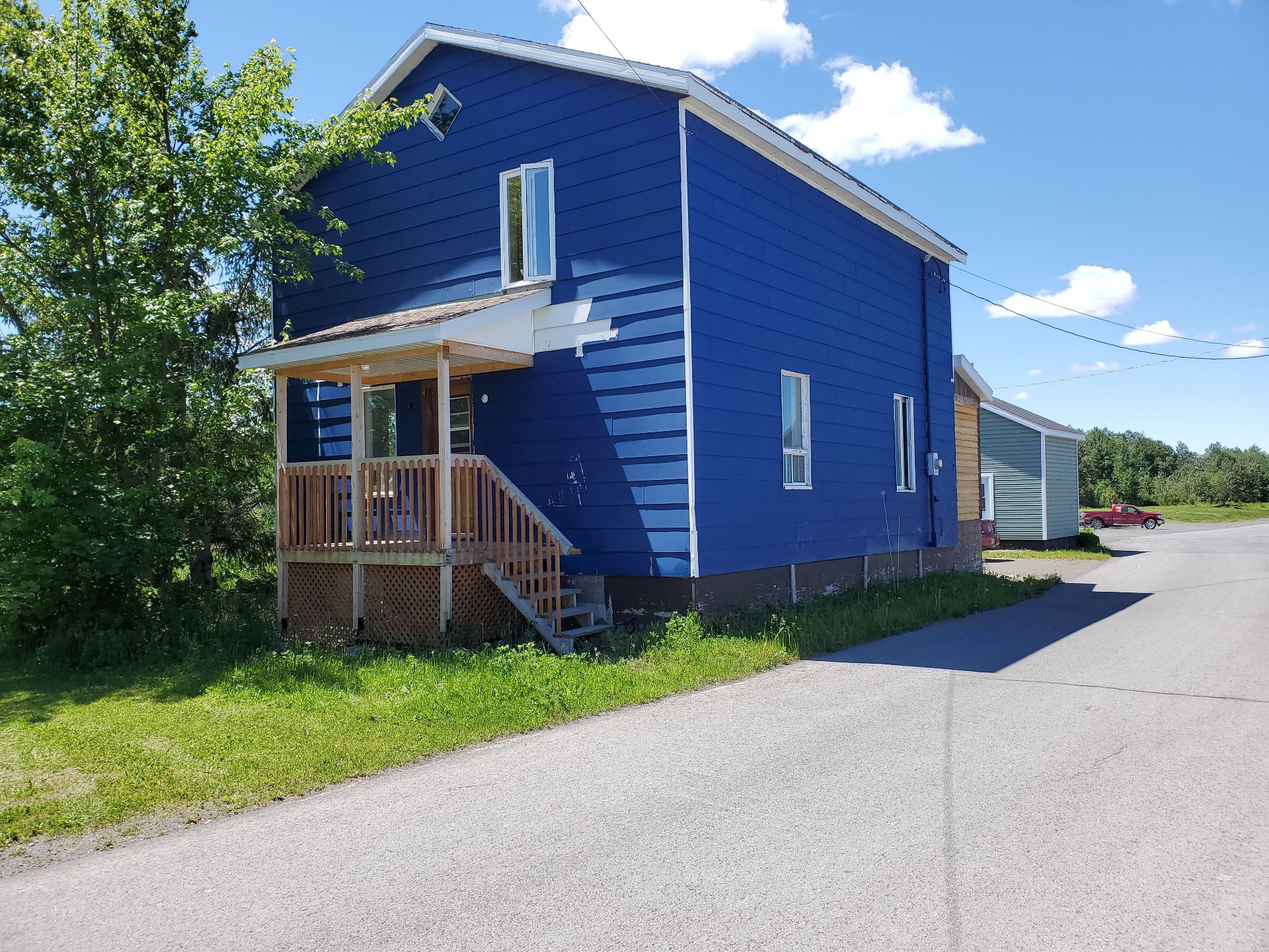 Bright blue home with small deck for sale in Quebec