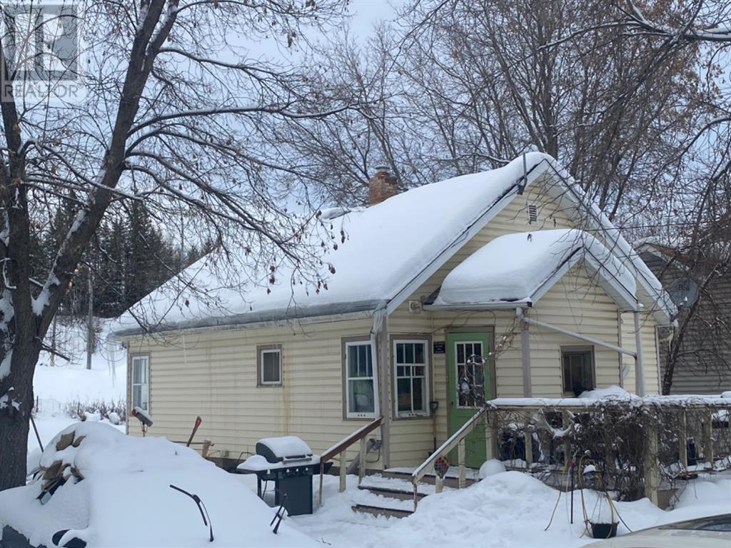 Beige home with green door covered in snow in Alberta