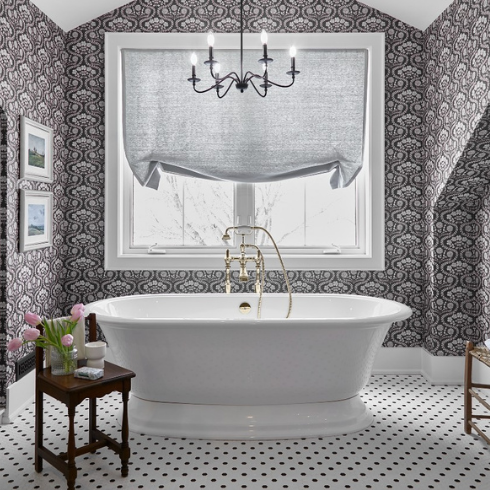 Charcoal grey and white floral wallpaper in an ensuite bathroom with a soaker tub