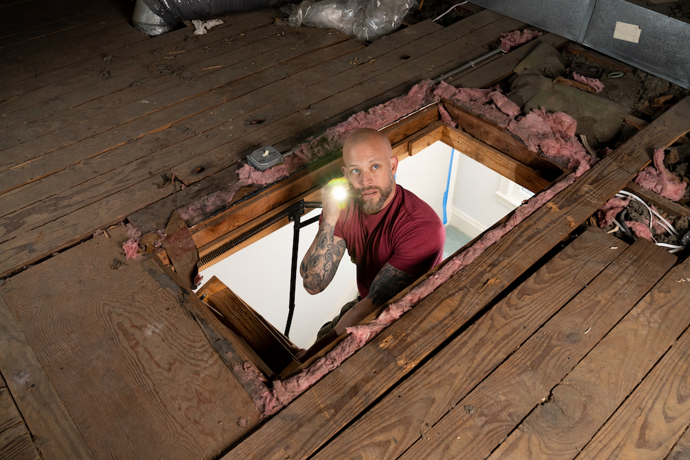 Home inspector Joe Mazza investigating an attic on Home Inspector Joe.