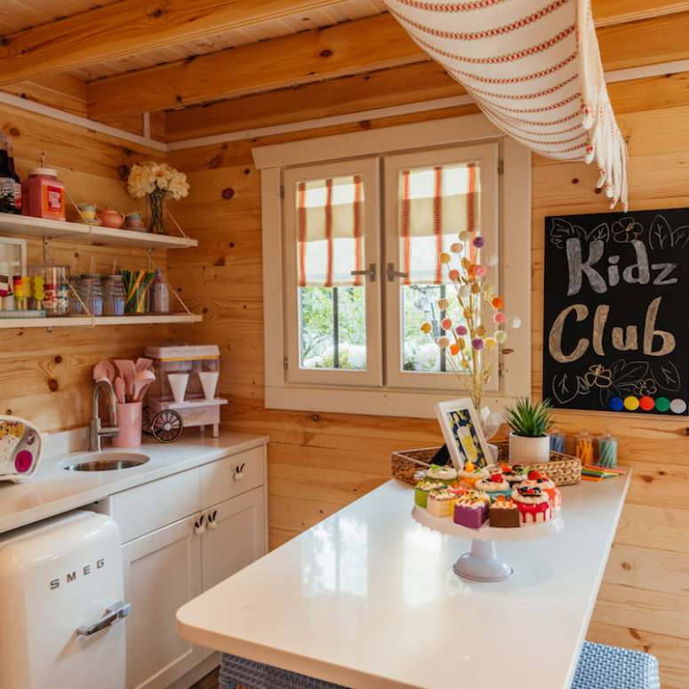 Play kitchen with wood paneling and smeg mini fridge