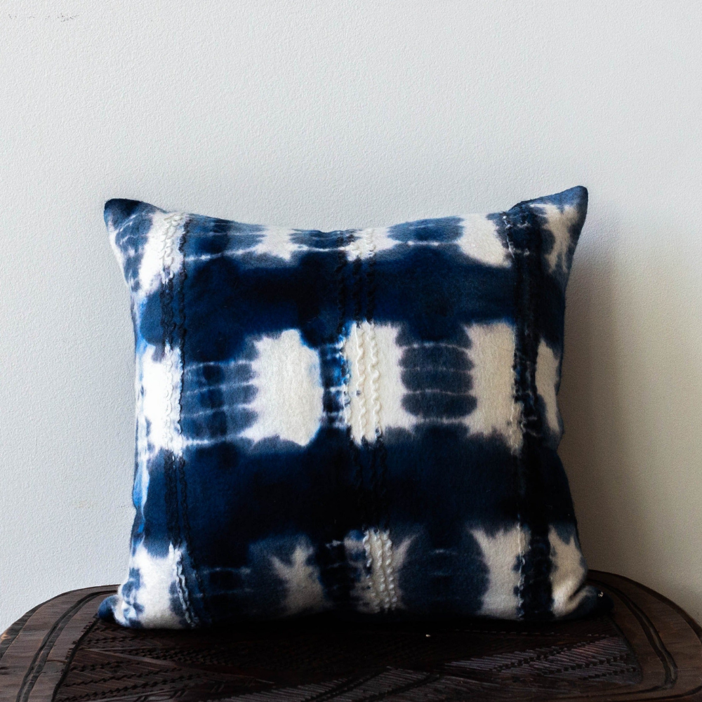 A blue and white tie dye adire cushion cover, the traditional style used by Yoruba people in their artisanal textiles.