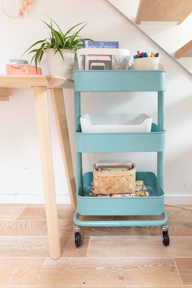 bright blue tiered cart beside wooden desk
