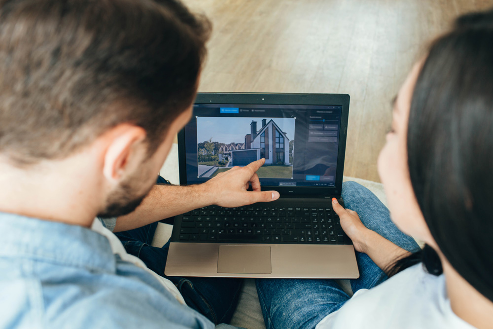 couple looking at a house on a laptop