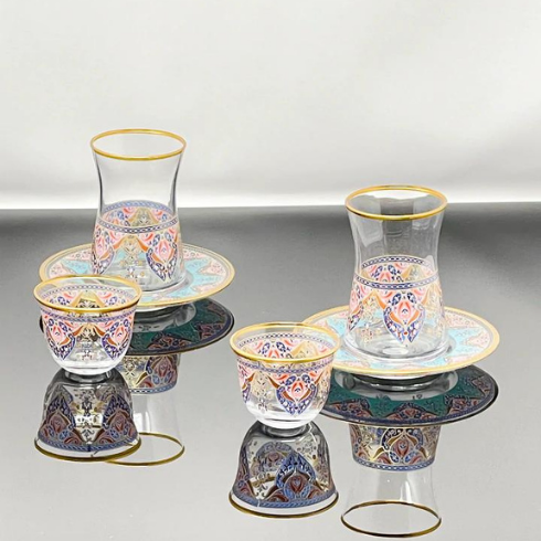 A set of Turkish-style glass tea cups and saucers with pink and blue detailing.