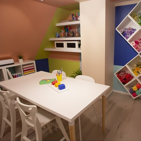 Colourful craft room with colorblocked walls and craft supplies in containers
