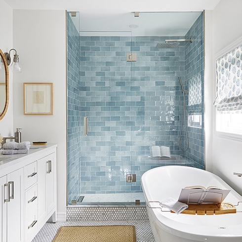 Blue and white bathroom with tiled shower and double vanity