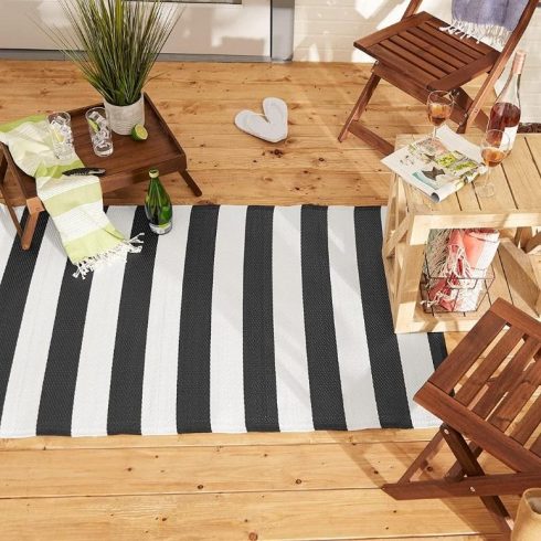 A black and white striped rug on a small balcony