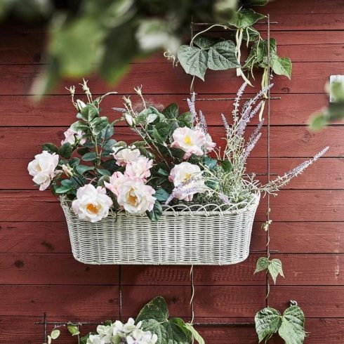A flower box with pink flowers on a small balcony