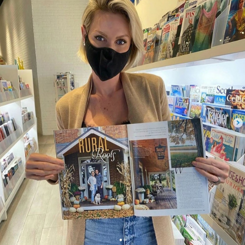 Carolyn Wilbrink holding a design magazine with photos of her projects