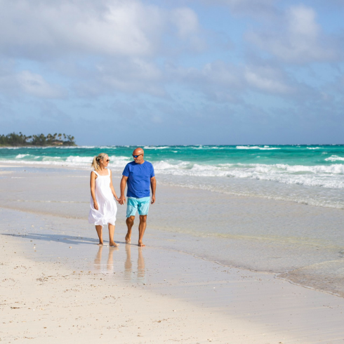Sarah and Bryan Baeumler walking along a sandy beach