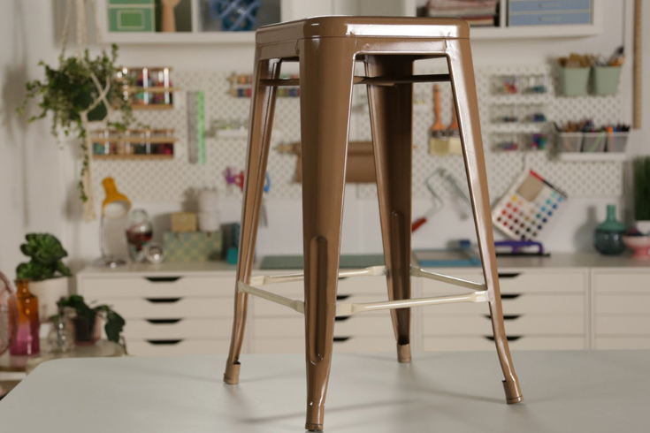 A metal stool spray-painted a warm brown all over.