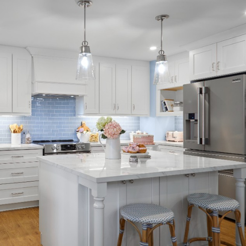 White kitchen with brushed nickel hardware and blue subway tile backsplash
