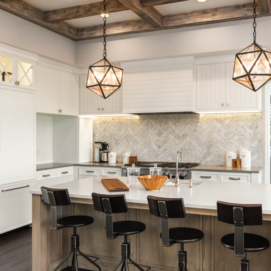 A photo of a modern rustic kitchen with a wood panel island, white counter tops and four black stools