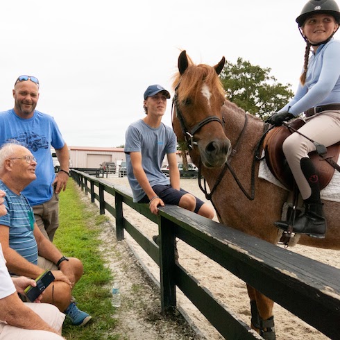 The Baeumler family in Florida watching Jojo riding a horse