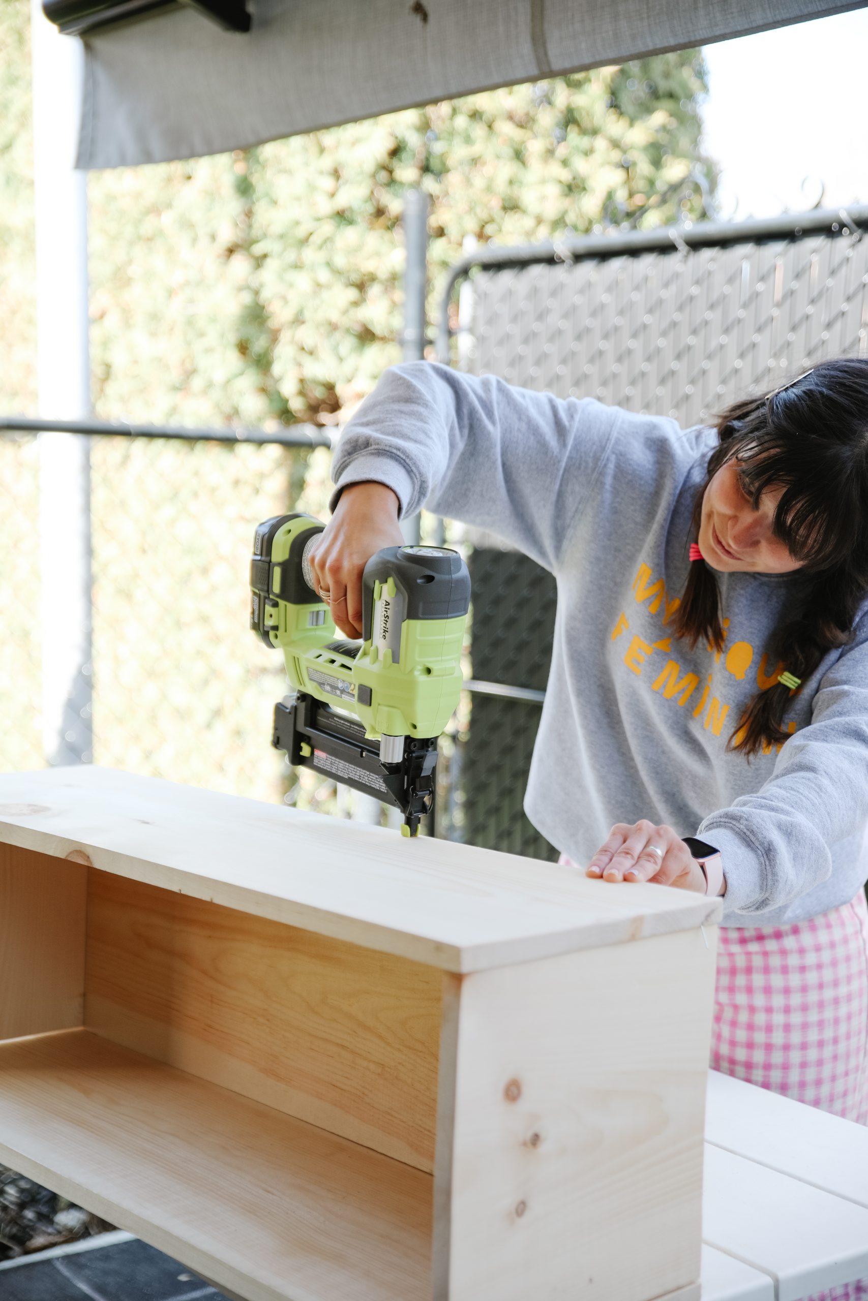 Maca assembling the DIY planter box by attaching pieces together.