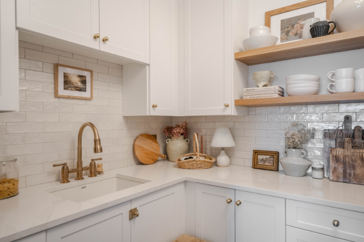 A corner of the kitchen add-on showing more white cabinetry as well as wooden open shelving.