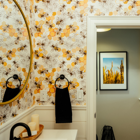 A bathroom with bee and honeycomb printed wallpaper