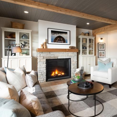 Living room with fireplace, wooden beam ceilings, and white couches