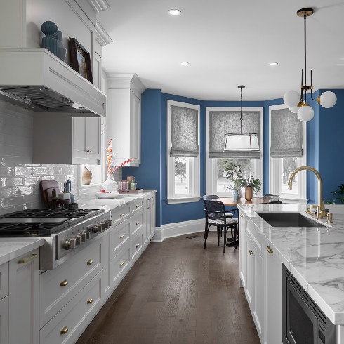 Modern kitchen with blue walls and white cabinetry