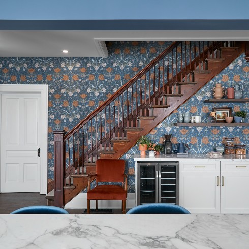 Exposed staircase with wood trim and floral wallpaper