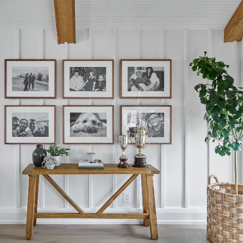 Black and white gallery wall over vintage wood table
