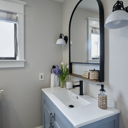 Renovated bathroom with a blue vanity and black accents