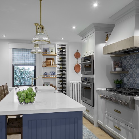 Renovated farmhouse kitchen with large blue kitchen island with white marble a top